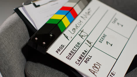 Close-Up-Of-Film-Clapperboard-Or-Slate-With-Production-Details-And-Script-Shooting-Movie-Or-Video-In-Studio-1